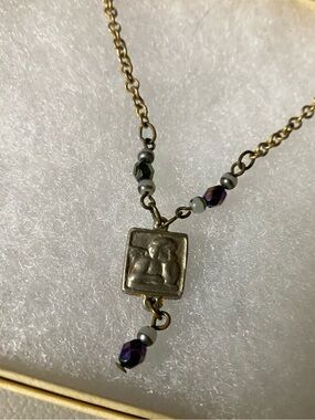 Gold-Tone square pendant Necklace with cherub and iridenscet Purple Beads